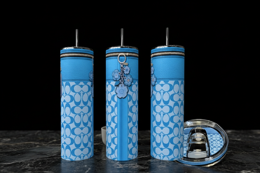 Three blue and white patterned tumblers with metal straws are displayed on a dark marble surface against a black background, with a clear lid with a metal straw holder shown on the right.