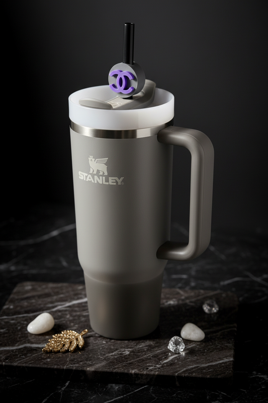 Gray Stanley mug with a white lid on a dark surface