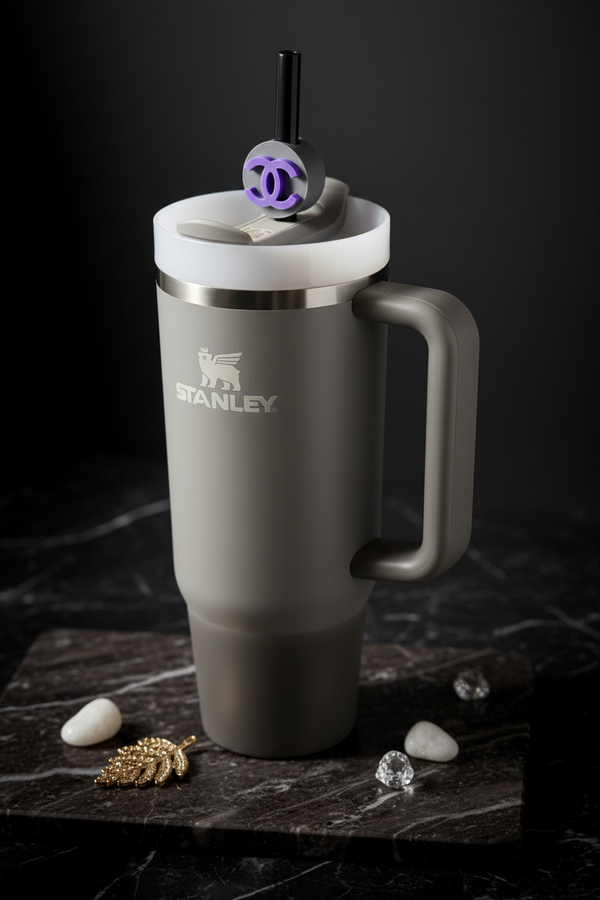 Gray Stanley mug with a white lid on a dark surface