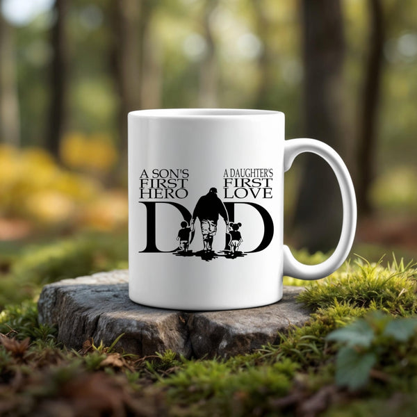 The A Sons First Hero - A Daughters First Love Dad Ceramic Mug by Kreative Kreationz features a seamless silhouette design with touching text—making it the perfect gift for dad. White ceramic mug displayed outdoors with forest greenery in the background.