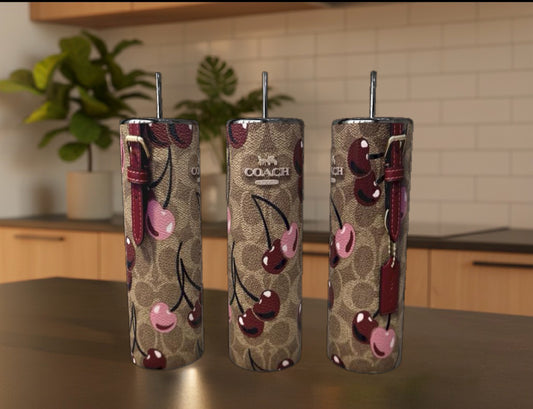 Three patterned tumblers with cherry design on a kitchen counter.