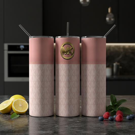 Three Kreative Kreationz stainless steel tumblers, featuring metal lids and straws, sit side-by-side. They have a pink top with a gold Michael Kors logo and a patterned lower section with a repeated MK design, against an elegantly blurred background.