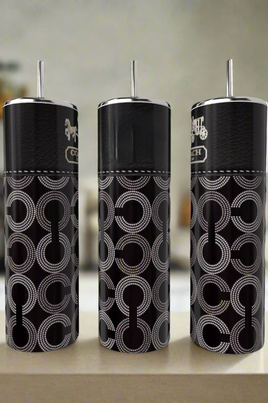 Three black tumbler cups with patterns on a kitchen counter