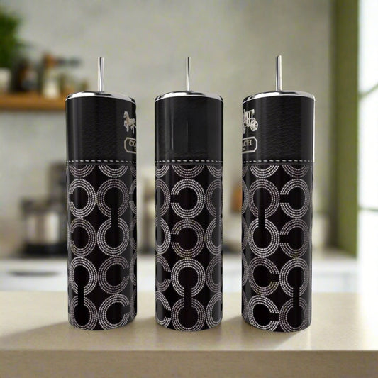 Three black tumbler cups with patterns on a kitchen counter