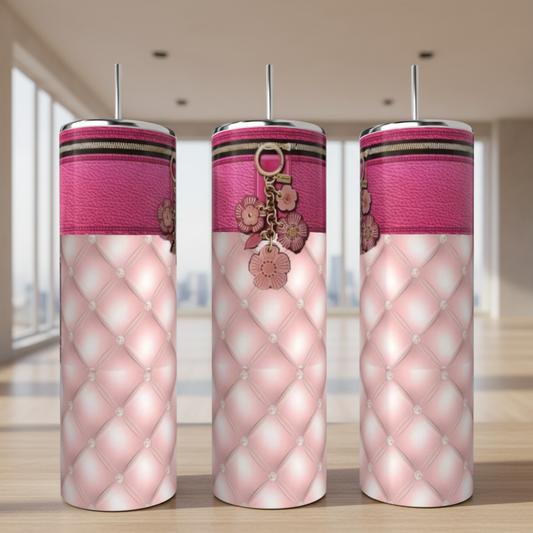 Three pink patterned tumblers with keychains on a blurred background
